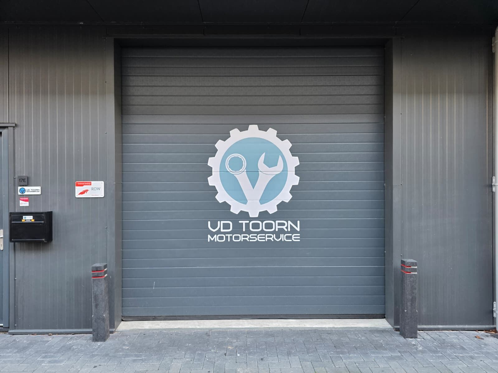 Gevel van de werkplaats aan de Egelskoog in Alkmaar, met het logo van VD Toorn Motorservice op de roldeur